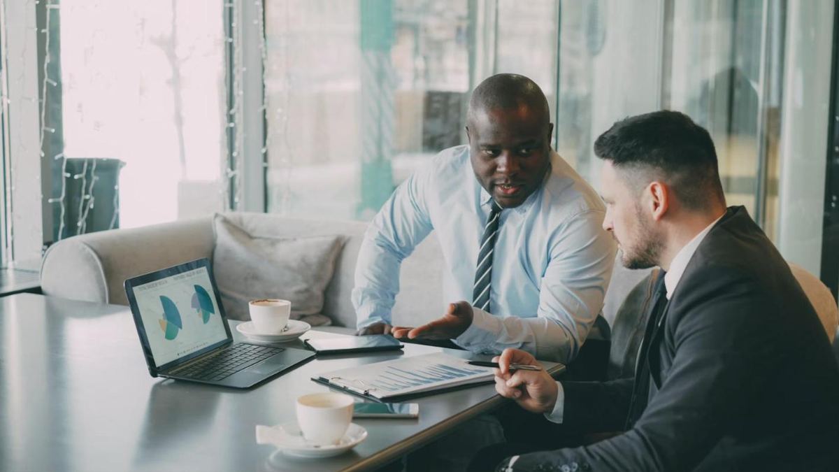 Dois executivos analisando resultados juntos em um notebook