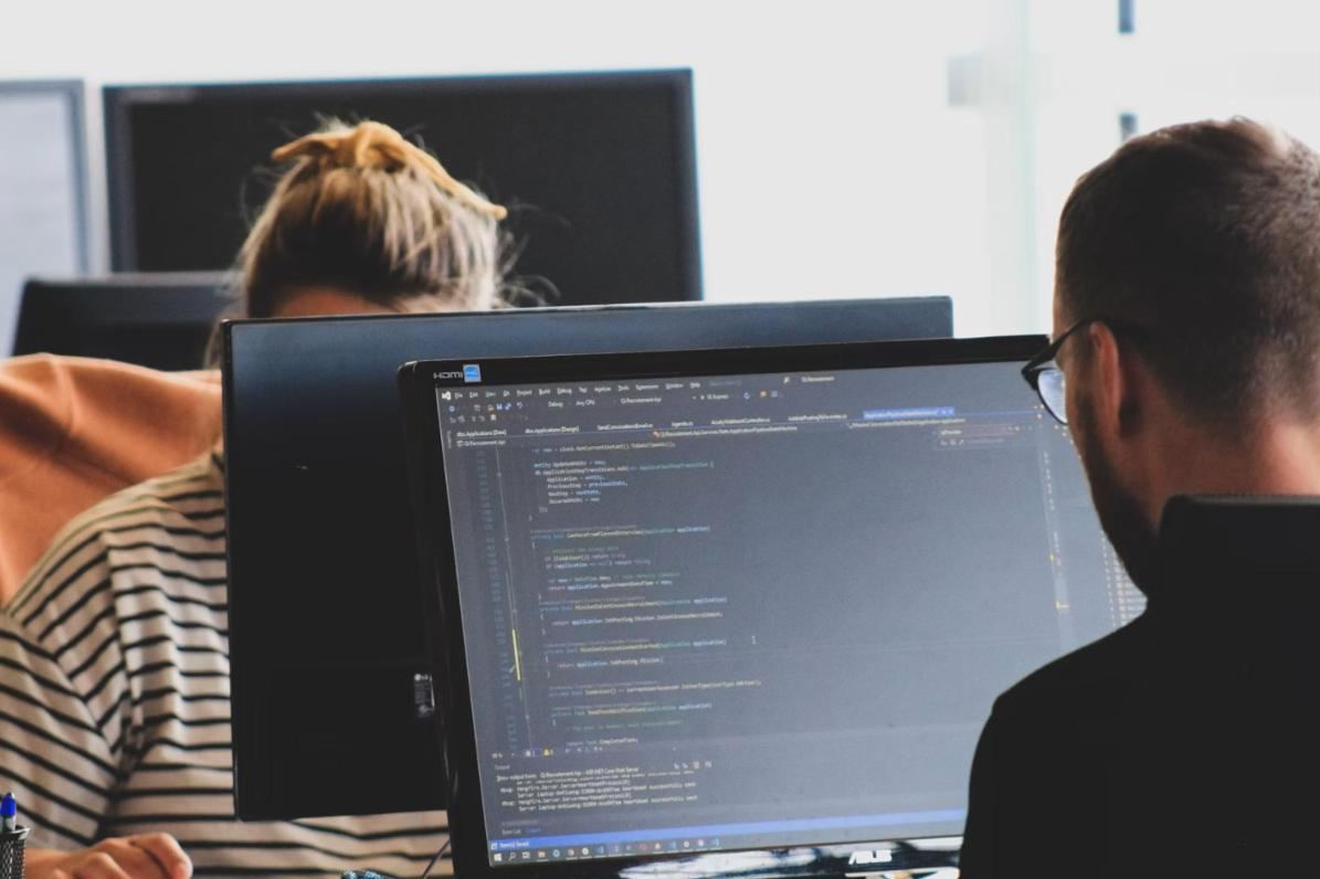 Engenheiros revisando código em monitores